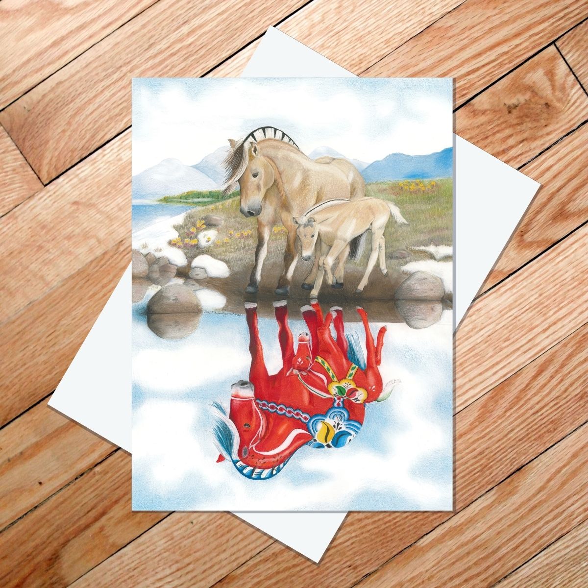 Greeting card of a Norwegian fjord and her foal looking at their reflections as red Dala horses