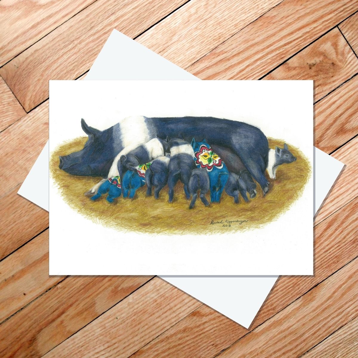 Greeting card of a Hampshire sow feeding a litter of piglets, several of which are Dala pigs