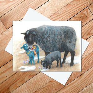 Greeting card of a Gotland sheep with two lambs, one which is blue and inspired by Swedish Dala horses