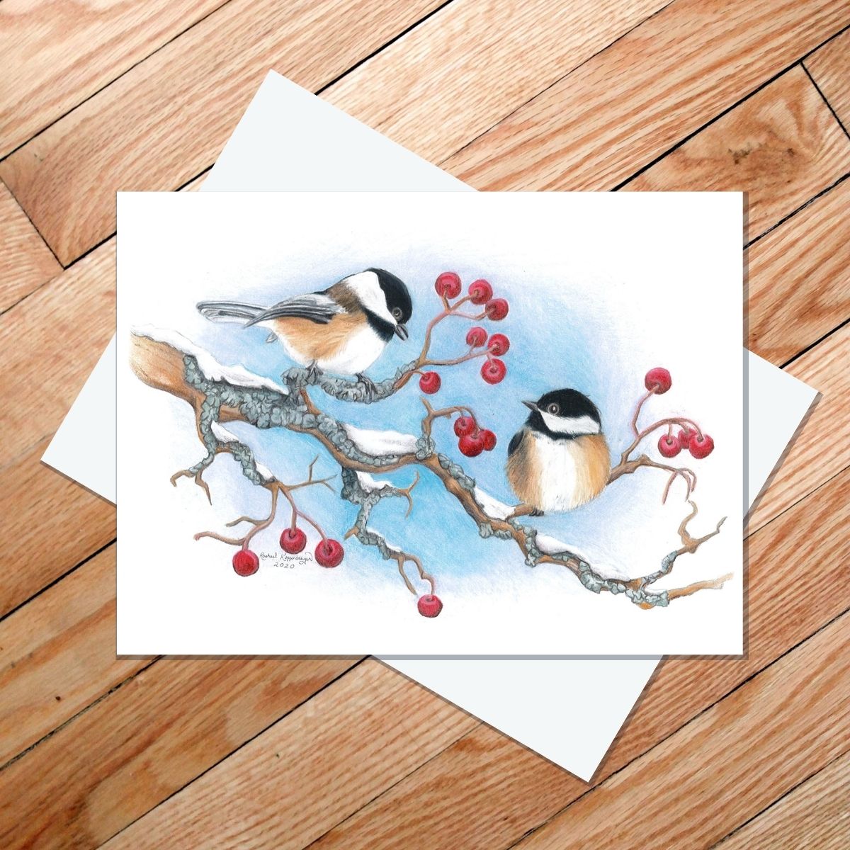 Greeting card of two black-capped chickadees on a snowy berry branch