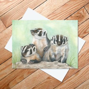 Greeting card of three baby badgers popping up out of their hole to look around